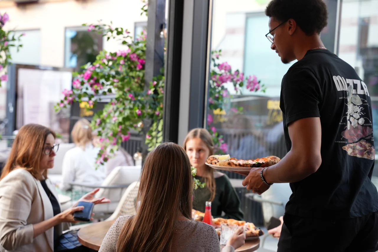 Servering bland gäster på Mozzas uteservering